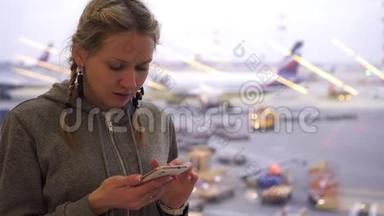 机场的女人带着智能手机。 机场候机楼的游客使用电话..